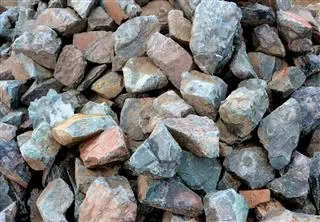 A pile of rough, jagged rocks and stones in varying shades of grey and brown.