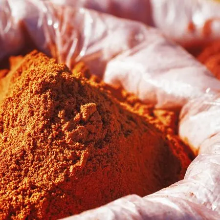 A mound of red cayenne pepper powder inside a clear plastic bag.