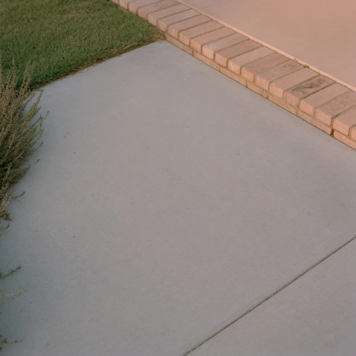 A smooth, light grey concrete driveway surface extending into the distance.