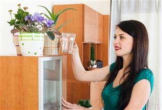 Woman Watering Flowers in Pots